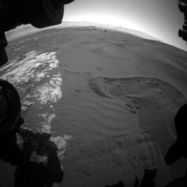 这张照片由好奇号前方的避险相机拍摄于2016年1月20日（第1229个火星日），显示了好奇号采集沙粒样品的区域。地面能看见在采集首份样品前，好奇号轮子搅动过沙子的痕迹，这是为了确保火星车的“挖土勺”在采样时避免触及硬质地表。