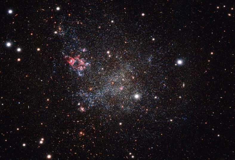 这张照片由欧洲南方天文台位于智利的VLT巡天望远镜拍摄，呈现了一个异常干净的小星系。 IC 1613内的宇宙尘埃非常少，使得天文学家能够清晰观测到其内部细节。