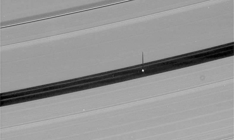 土卫十八在土星A环上投下一道细长的影子。图片中央的巨大空隙正是土卫十八所在的恩克环缝，宽达325公里，其中还有数条淡淡的细环。土卫十八的碟形突起可能仍然在从这些细环当中积聚物质。