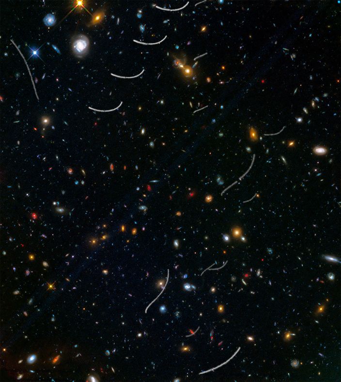 这幅照片来自一片随机的天区，属于“前沿视场(Frontier Fields)”调查项目的一部分。照片中捕捉到数以千计的星系，大型的黄色椭圆星系和壮观的蓝色螺旋星系非常醒目，而一些更小的蓝色星系则散落于整个天区。其中，那些颜色最红的天体极有可能是最为遥远的星系，它们的光线发生了“红移”。 除了这些遥远的星系，几颗调皮的小行星闯入画面，留下了它们的身影，画出一道道弯曲状或S形的轨迹。由于整个照片，是哈勃望远镜多次曝光后合成而来，因此照片中的小行星轨迹并不连续。实际上，这20道轨迹来自于7颗小行星，其中2颗之前就已经被发现，其余的则太暗弱未曾被观测到。