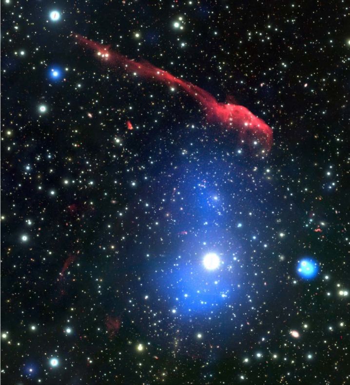牙刷星系团多波段的伪彩色图像，红色部分标记射电源，蓝色部分为X射线辐射，背景图片来自可见光波段。