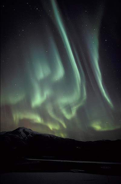 2003年10月29日，美国阿拉斯加州安克雷奇的东北部山脉上空出现美丽的极光。